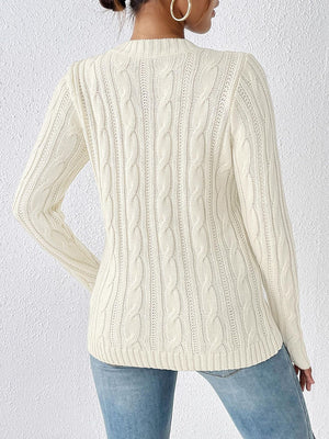 Ivory cable knit mock neck sweater with long sleeves and textured knit details.