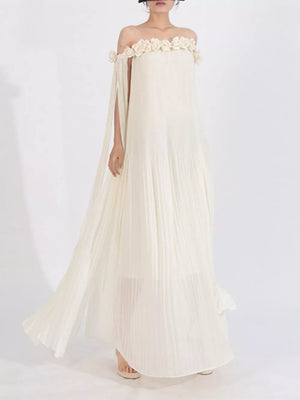 Elegant off-shoulder maxi dress in cream with floral appliques and cape sleeves.
