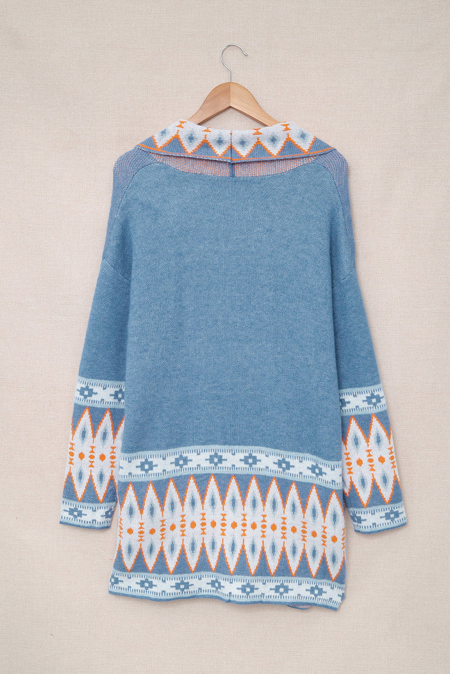 Blue knit cardigan with geometric trim on collar and sleeves.