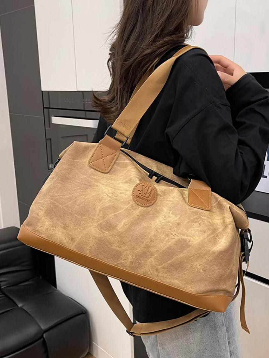 Brown Oxford cloth duffel bag with leather trim and detachable strap.