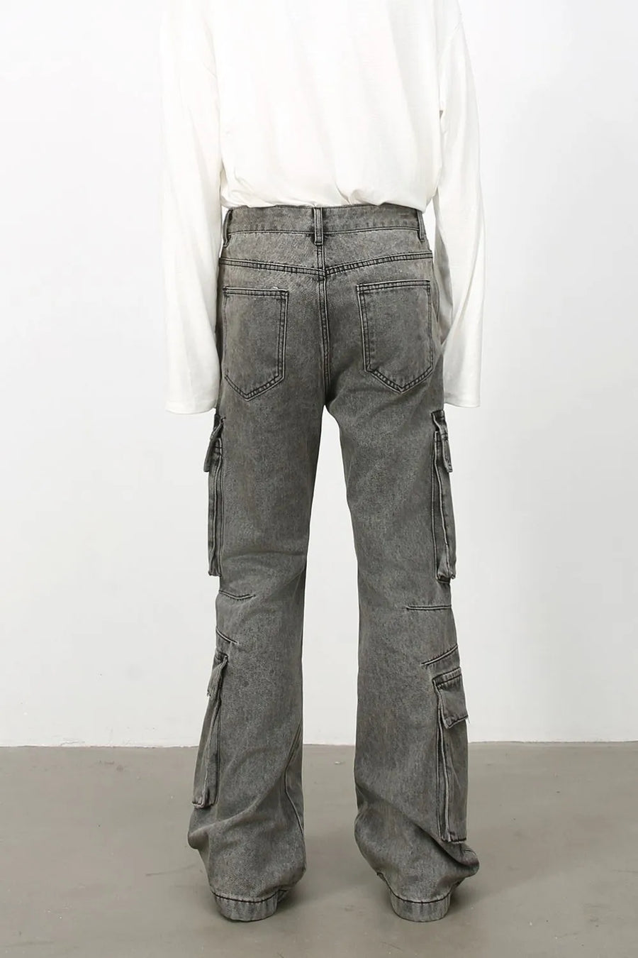 Acid wash flared cargo denim pants in medium, featuring multiple pockets and a relaxed fit.