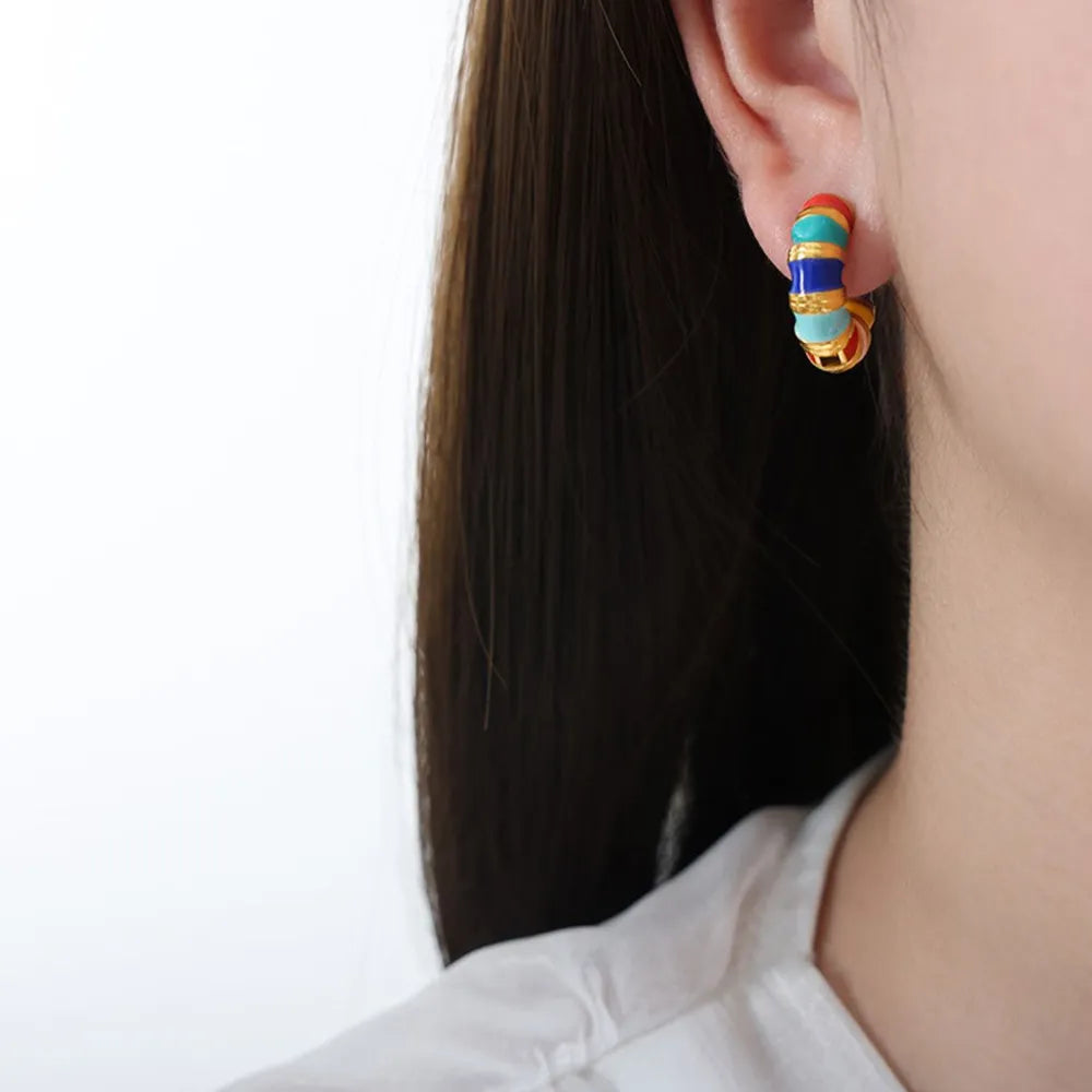 Gold hoop earrings with colorful segmented enamel and gold details.