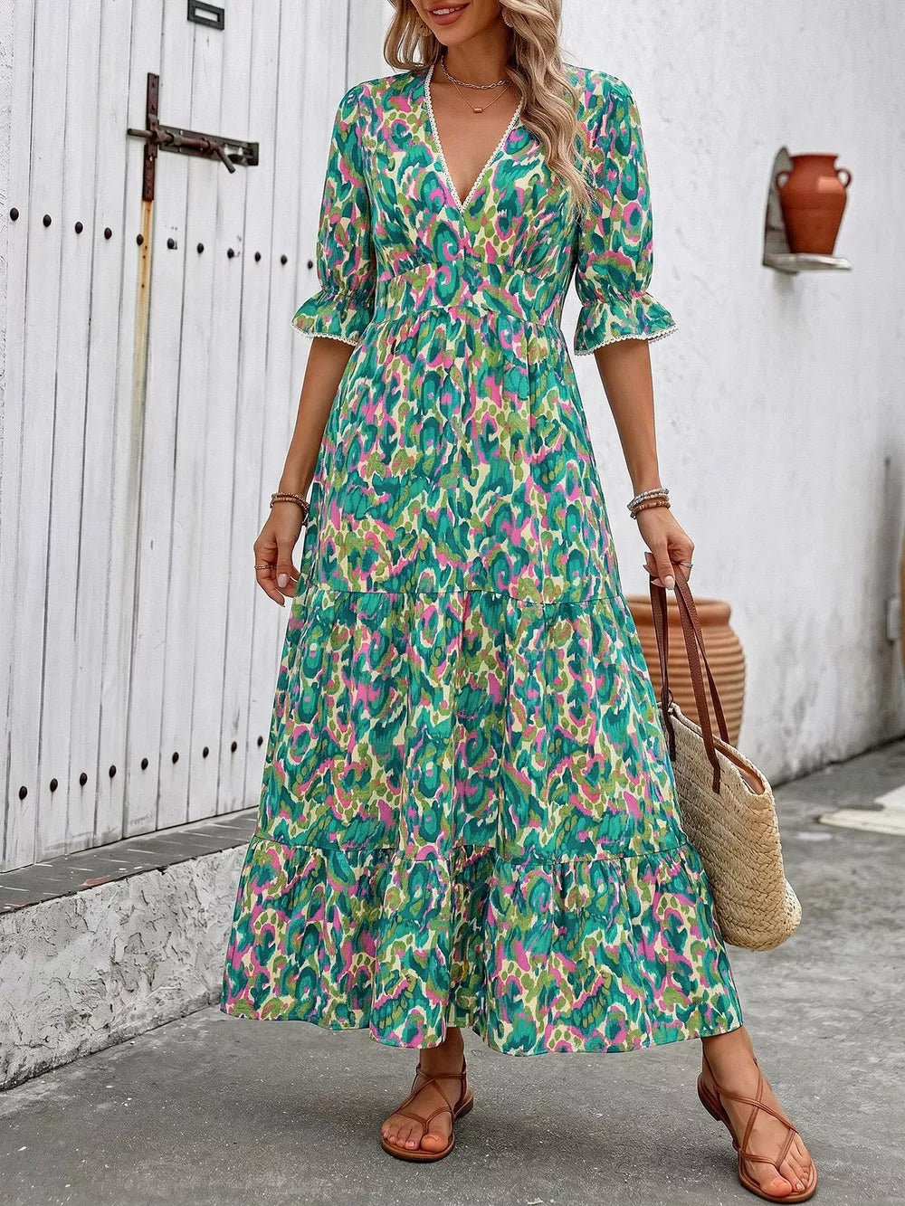 Vibrant V-neck maxi dress with abstract print, flounce sleeves, and tiered skirt.
