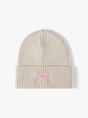 Beige ribbed knit beanie with embroidered pink bow detail