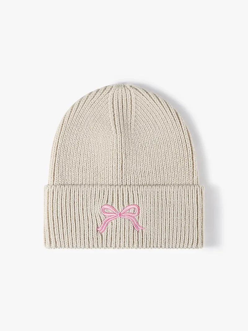 Beige ribbed knit beanie with embroidered pink bow detail