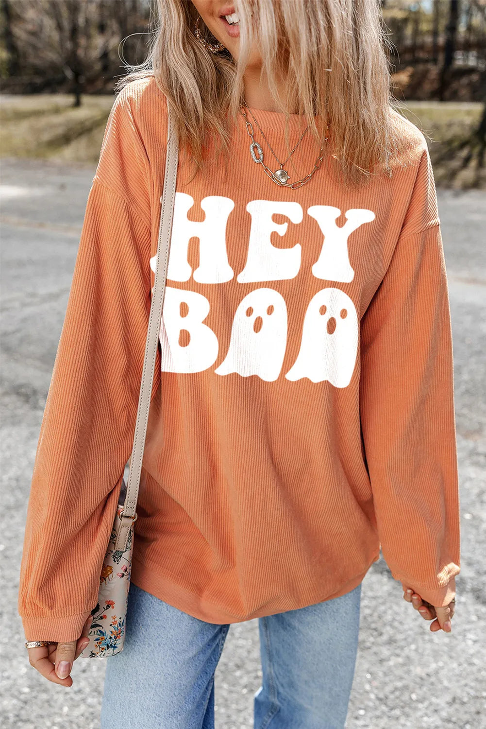 Corduroy sweatshirt in sherbet orange with "Hey Boo" ghost graphic, long sleeves.