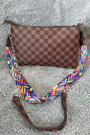 Brown checkered print shoulder bag with studded detail and colorful patterned strap.