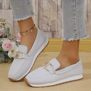 White mesh slip-on loafers with gold buckle detail and white sole.