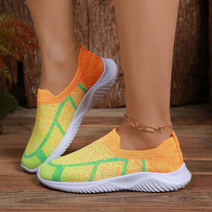 Geometric knit slip-on trainers in orange and yellow with green accents.
