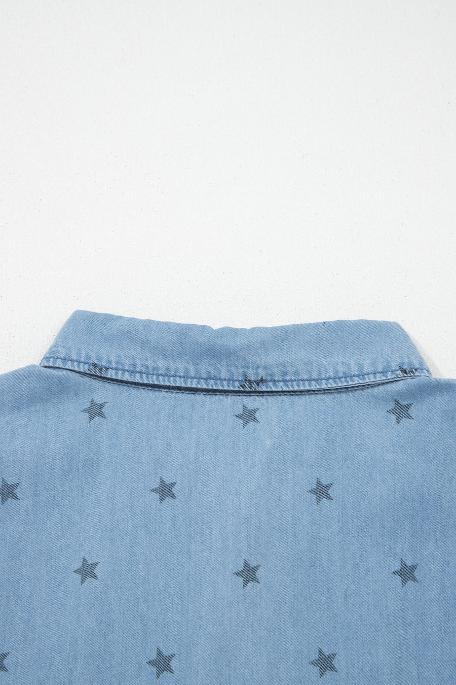 Light blue denim button-down shirt with dark grey star print and collar detail.
