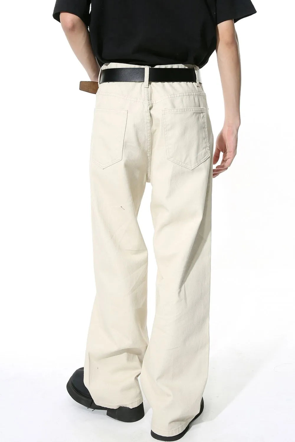 Cream wide-leg denim jeans with angular seams and back pockets.