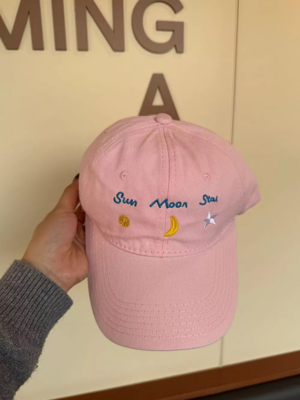 Blush pink cotton baseball cap with embroidered sun, moon, and star details.
