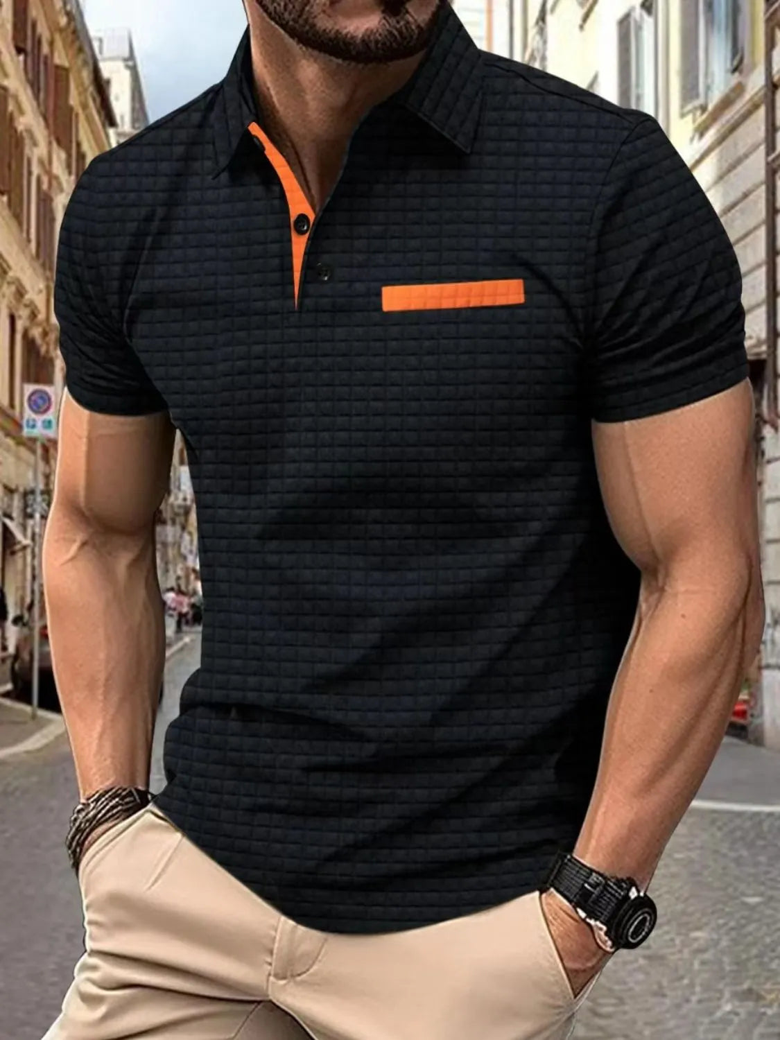 Black textured polo shirt with orange contrast collar and pocket detail.
