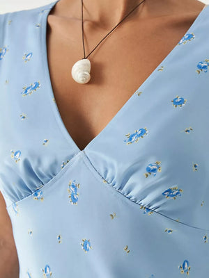Blue floral print v-neck mini dress with ruched bust detail.