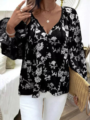 Black embroidered sheer long-sleeve blouse with button detail and floral pattern.