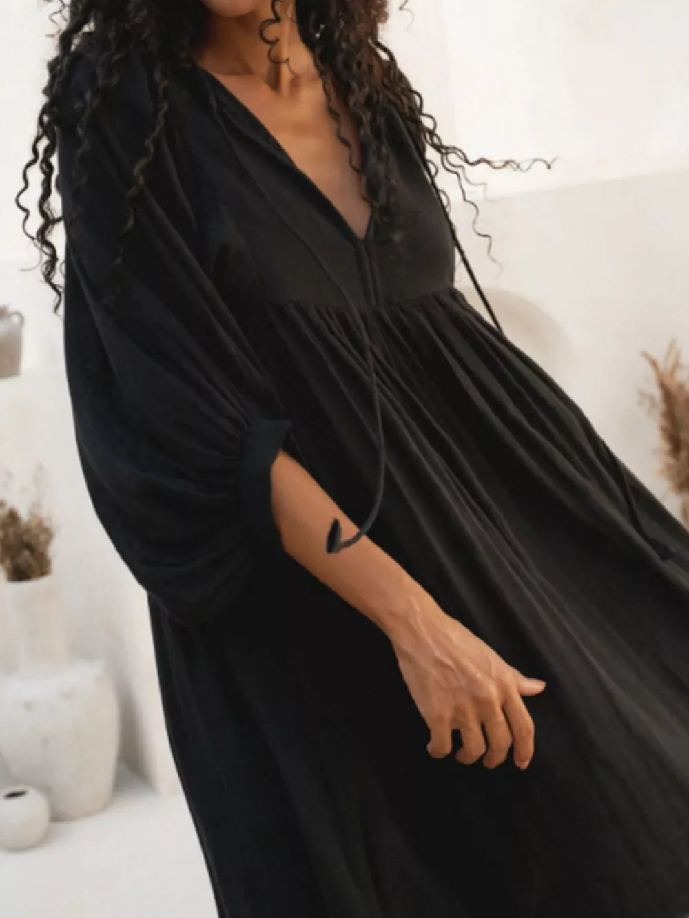 Black tie-neck midi dress with puff sleeves and tiered skirt