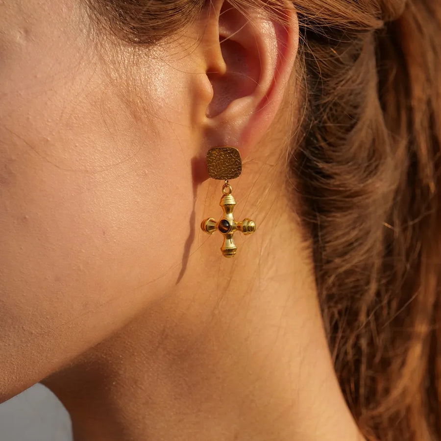 Textured cross drop earrings in 18K gold-plated metal with a dark stone detail.