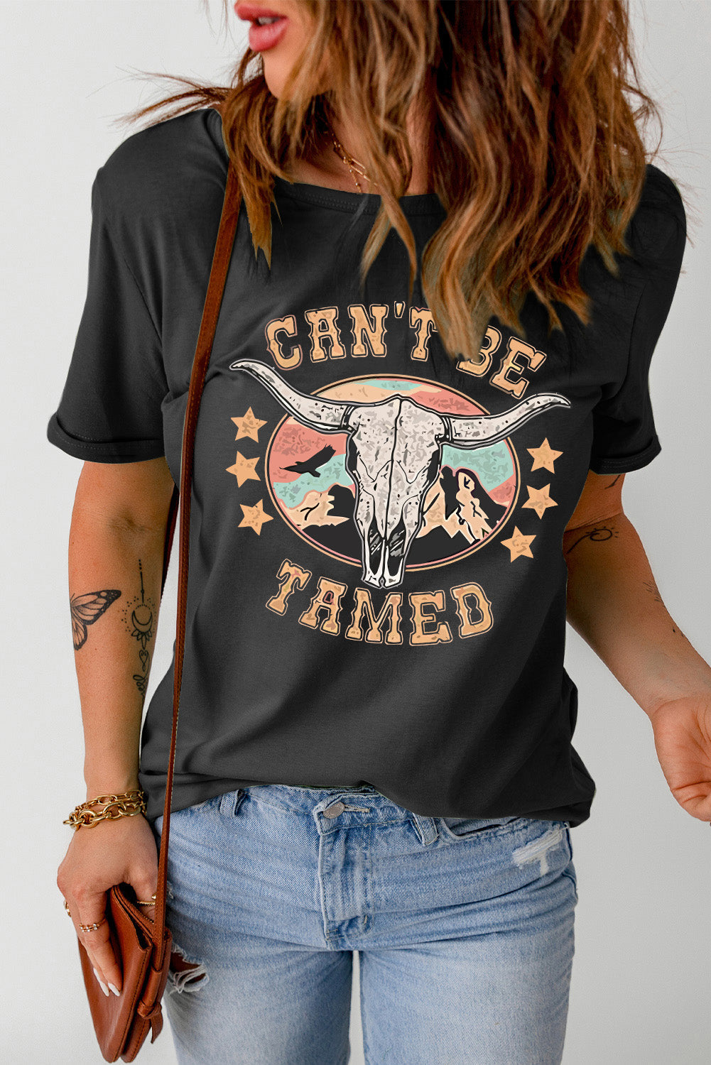Black graphic tee with a bull skull and "Can't Be Tamed" text.