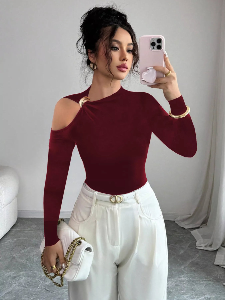 Burgundy one-shoulder t-shirt with cutout and gold ring detail, long puff sleeves.