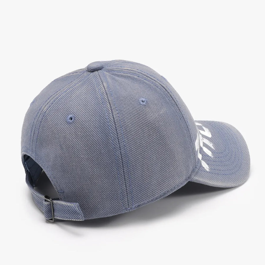 Textured denim baseball cap in Dusty Blue with white graphic detail and adjustable strap.
