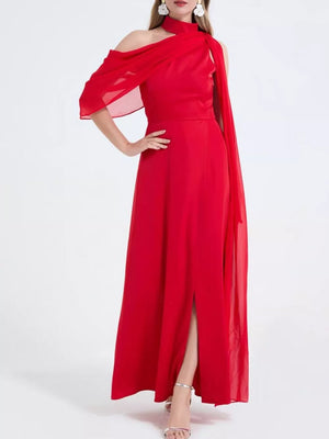 Red asymmetrical maxi dress with high slit, cold shoulder, and flowing cape detail.