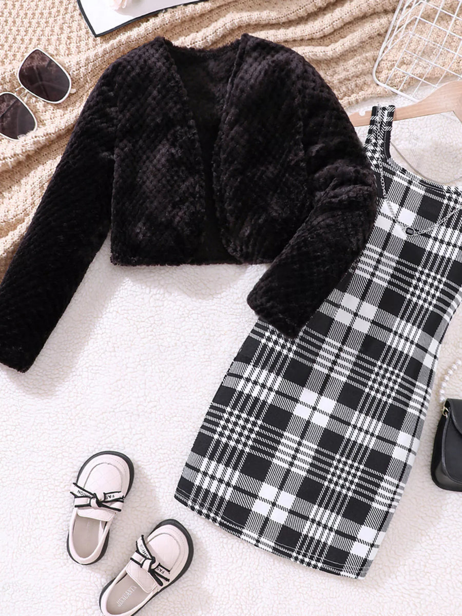 Black fuzzy cardigan with long sleeves and a plaid dress.