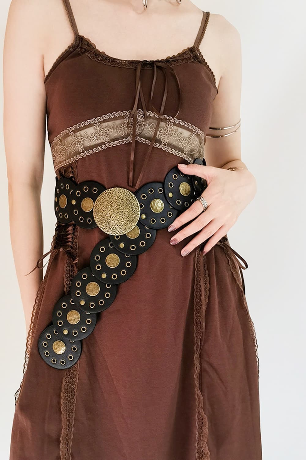 Black faux leather belt with gold discs and grommets, statement buckle