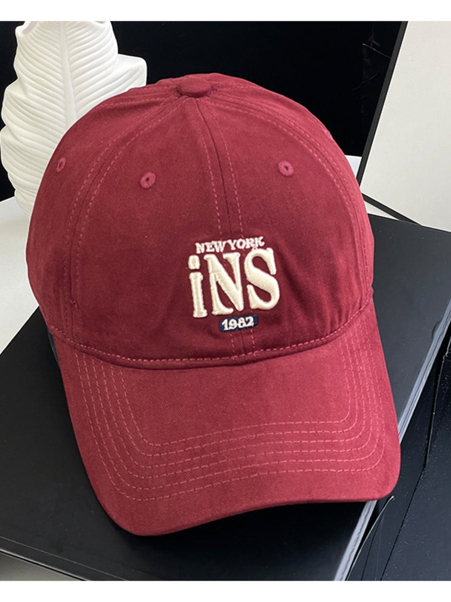 Maroon baseball cap with embroidered New York INS 1982 detail.