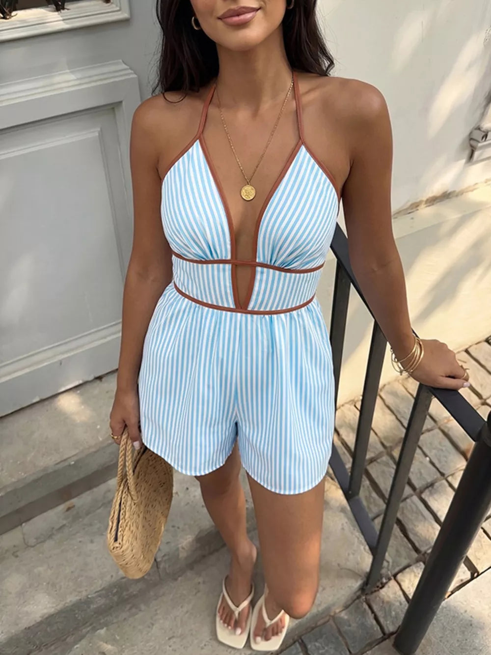 Blue striped halter romper with deep V-neck and brown trim.