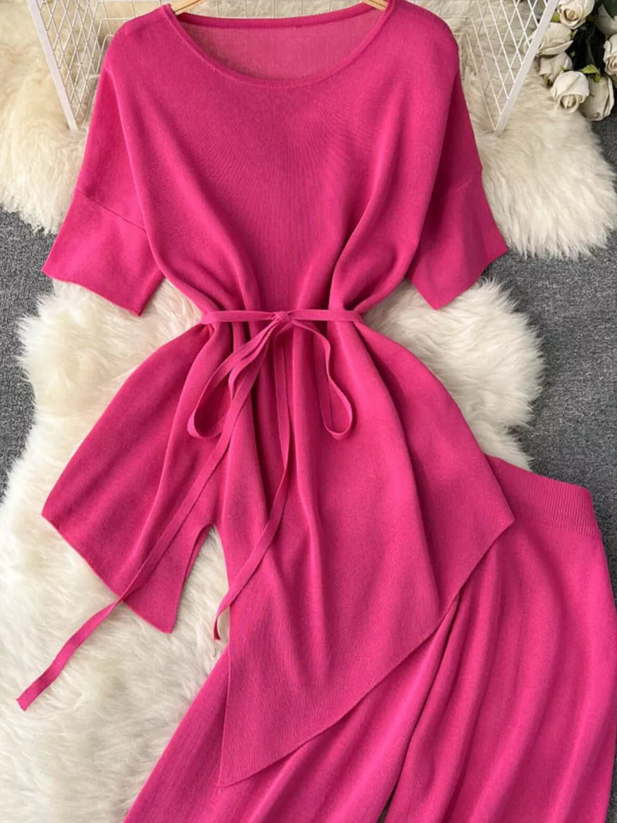 Tied waist knit two-piece set in bright pink with wide leg pants and short sleeves.