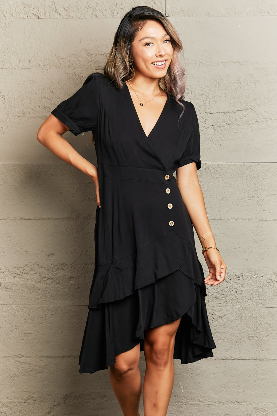Black viscose wrap dress with button detail and asymmetric ruffled hemline