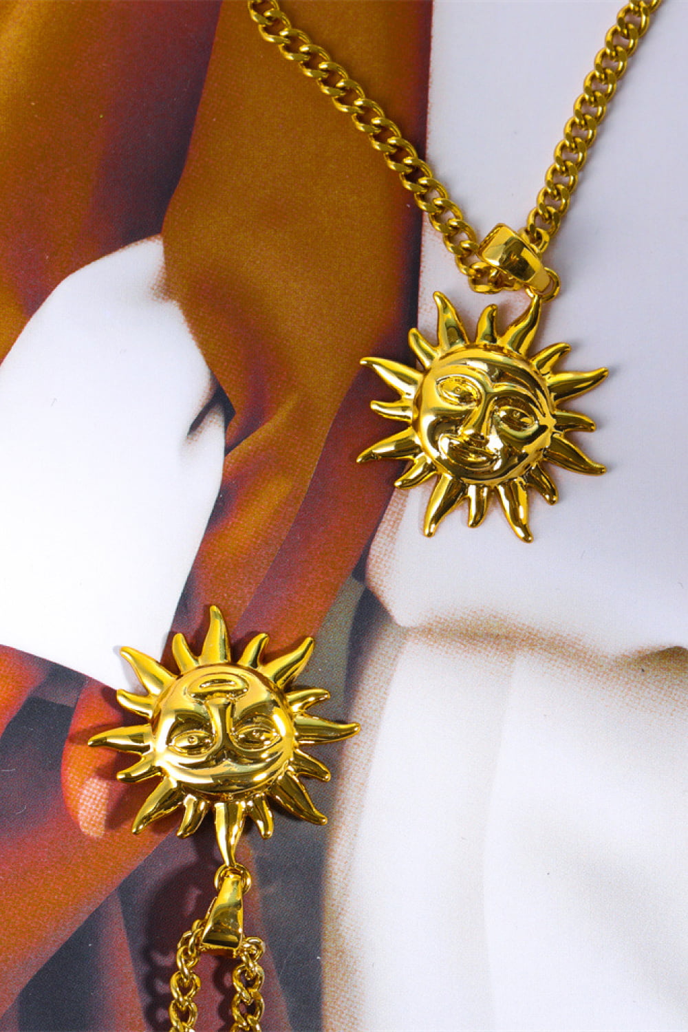 Gold sunburst pendant necklace with curb chain, featuring a detailed sun face charm.