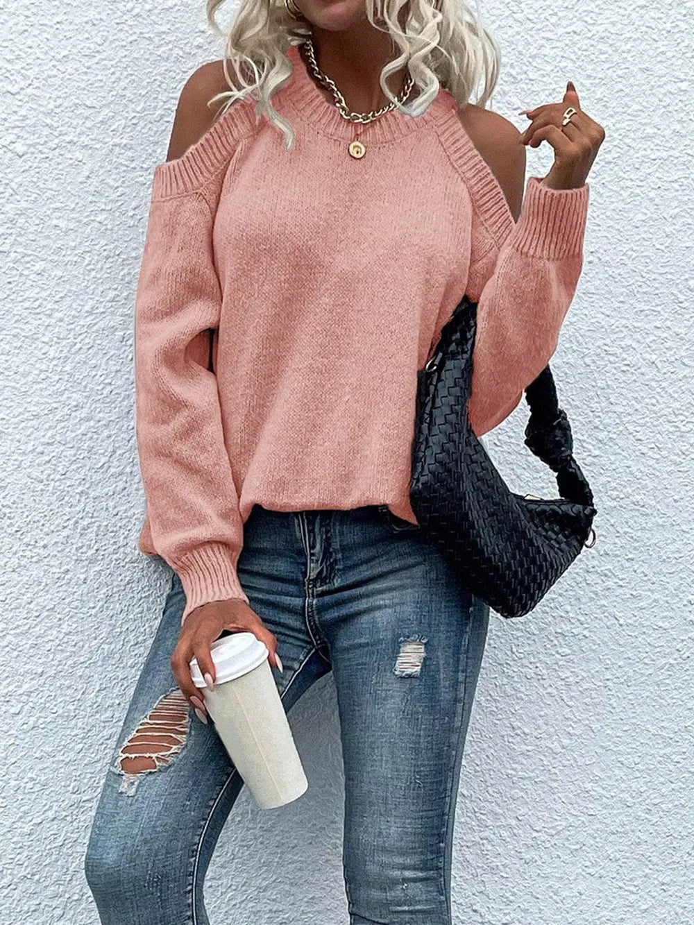 Pink cold shoulder knit sweater with crew neck and long sleeves.