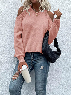 Pink cold shoulder knit sweater with crew neck and long sleeves.