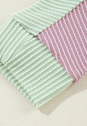 Waffle knit shirt with colorblock pattern in dusty pink and green with textured stripes.