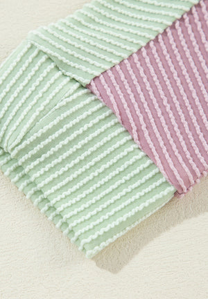 Waffle knit shirt with colorblock pattern in dusty pink and green with textured stripes.