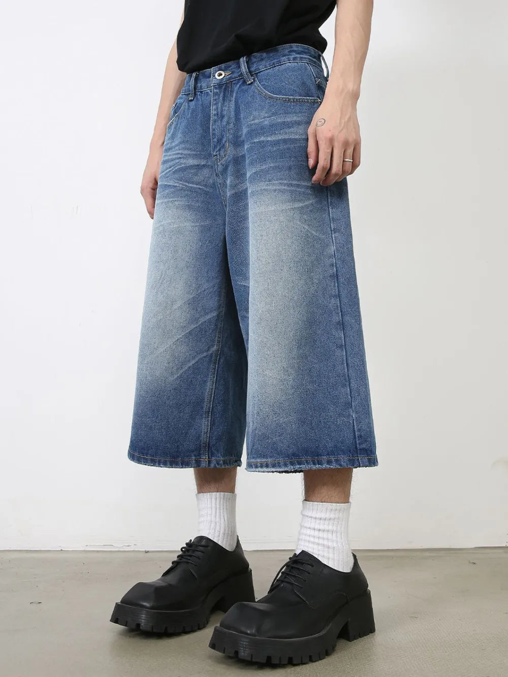 Wide-leg denim culotte shorts in blue wash with a relaxed fit and buttoned closure.