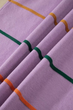 Vibrant striped knitted sweater vest in lavender with green and orange stripes.