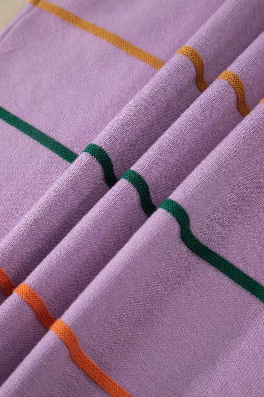 Vibrant striped knitted sweater vest in lavender with green and orange stripes.