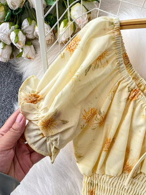 Floral ruffled crop top with puff sleeves and smocked waist in yellow chiffon.
