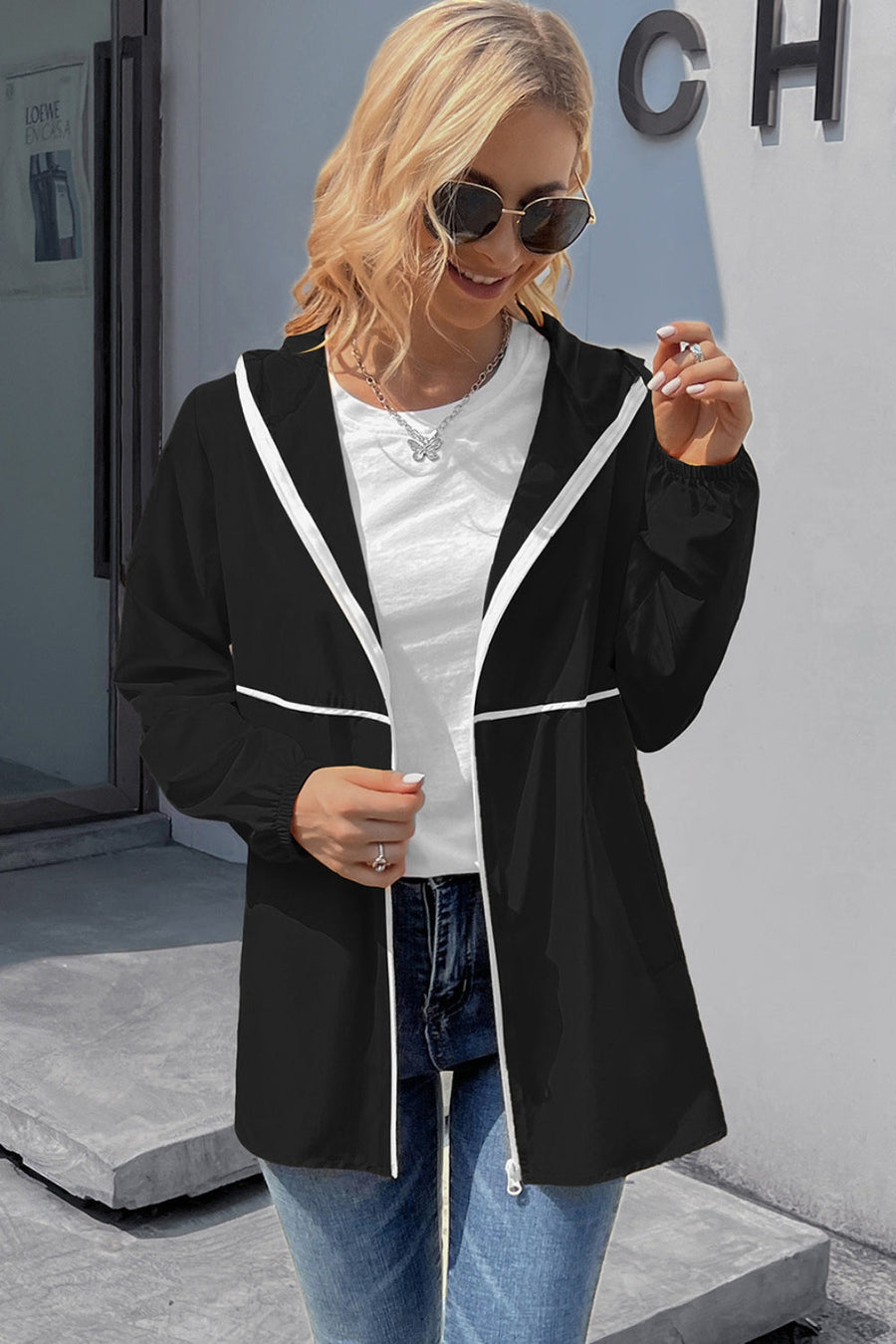 Black hooded rain coat with white trim and zipper closure.