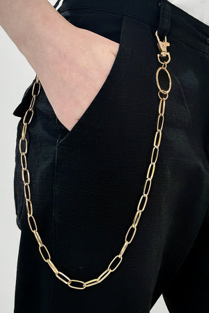 Gold chain wallet chain with oval links and lobster clasp attached to black pants.