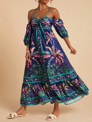 Navy tropical print maxi dress with smocked bodice, cold shoulder sleeves, and tie front.