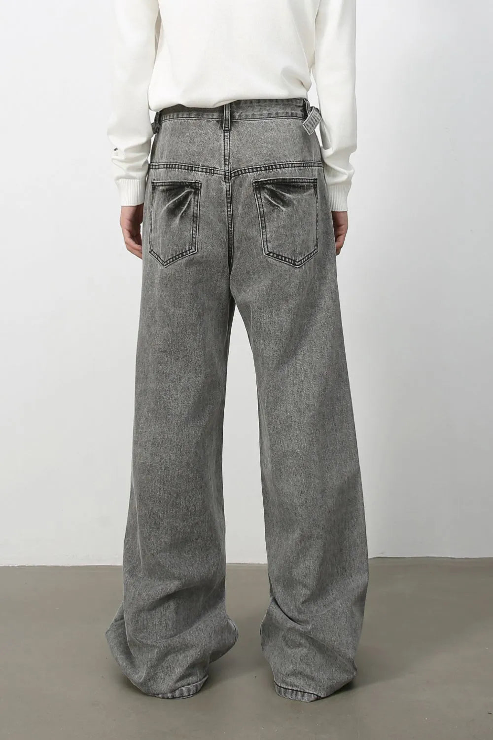 Wide-leg washed denim jeans in dark gray with a belt detail and relaxed fit.