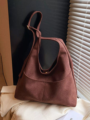 Large minimalist suede shoulder bag in brown with adjustable strap and front pocket.