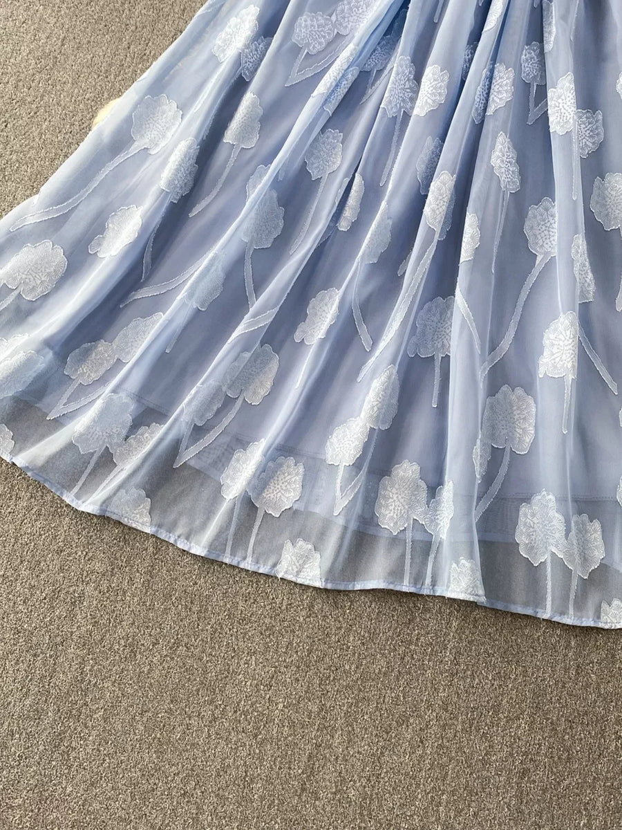 Blue chiffon maxi dress with white floral embroidery and a belted waist.