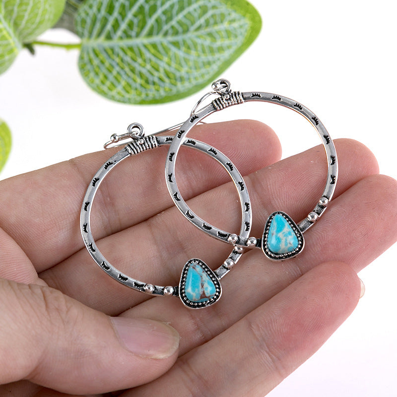 Southwestern stone hoop earrings in silver with turquoise inlay and boho detailing.