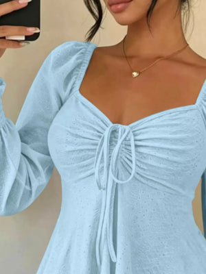 Pink peplum top featuring tied and eyelet