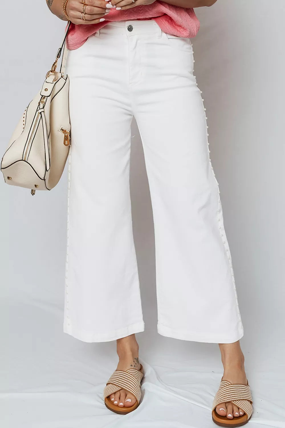 White relaxed fit ankle length denim jeans with pearl embellishments down the side seams.