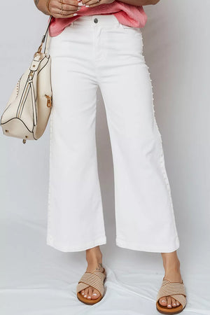 White relaxed fit ankle length denim jeans with pearl embellishments down the side seams.